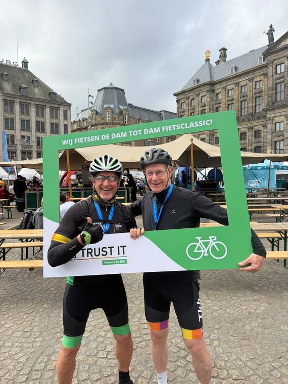 Twee fietsers in TRUST IT-tenue met hun finishmedaille